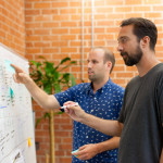 2 hommes travaillent sur le marketing automation sur un tableau blanc